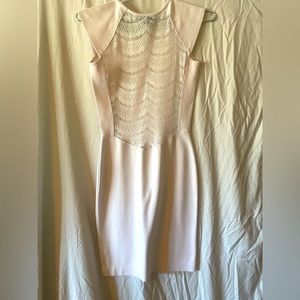 Small blush colored with detailed back, above the knee form fitting dress